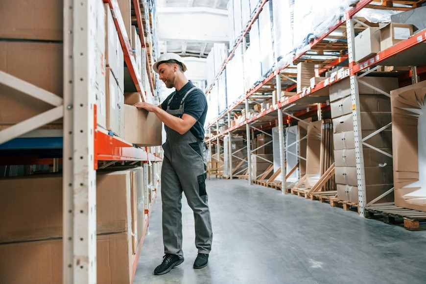 A young man working in a storage room filled with boxes