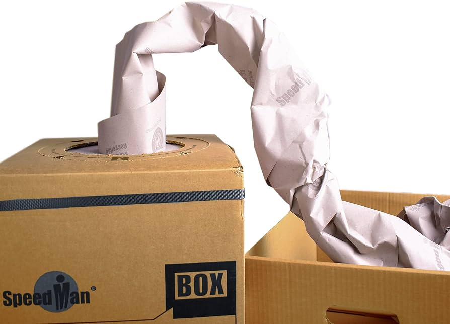 A SpeedMan Box dispenser with crumpled paper void fill material being pulled into a cardboard packing box.